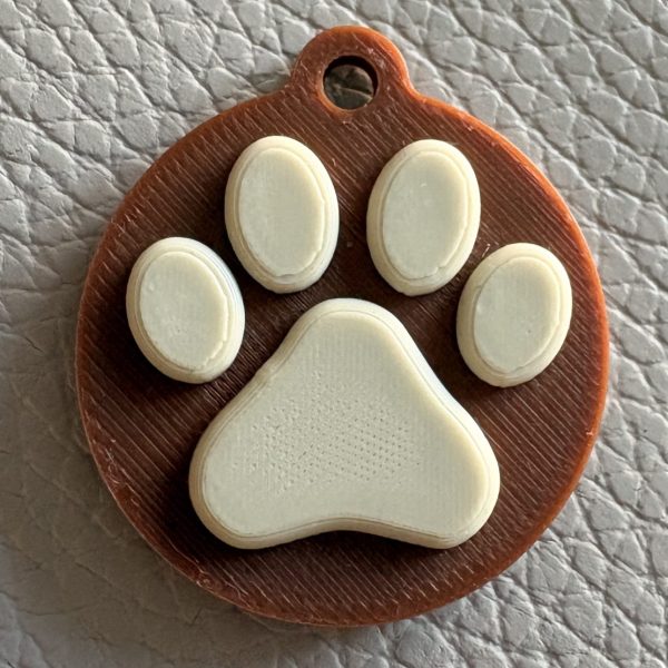 NFC pet tag with paw print design in brown and cream
